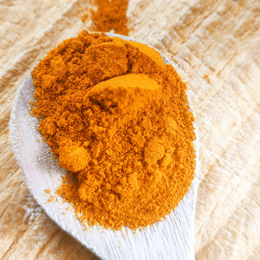 Curcuma moulu sur une cuiller en bois